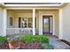 Inviting front porch with decorative flowers, brick walkway, and glass paneled door at 995 Hidden Blf, Clermont, FL 34711