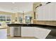 This kitchen features stainless appliances, granite counters, white cabinets, and a view into the living room at 995 Hidden Blf, Clermont, FL 34711