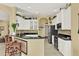 Bright kitchen featuring white cabinetry, a breakfast bar, and modern black appliances at 995 Hidden Blf, Clermont, FL 34711