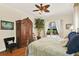 This main bedroom features an armoire, a ceiling fan, wood floors, and a large window with curtains at 995 Hidden Blf, Clermont, FL 34711