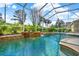 Enclosed pool with waterfall feature and lush landscaping at 995 Hidden Blf, Clermont, FL 34711