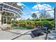 Relaxing screened-in pool with spa, waterfall feature, lush landscaping, and comfortable lounge chair at 995 Hidden Blf, Clermont, FL 34711