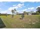 Large backyard with green grass, young trees, and view of neighboring houses at 10177 Spring Lake Dr, Clermont, FL 34711