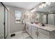 Bright bathroom featuring a double sink vanity, a large mirror, and walk-in shower at 10177 Spring Lake Dr, Clermont, FL 34711