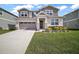 Charming two-story home with a well-manicured lawn and gray exterior with stone trim accents and a two car garage at 10177 Spring Lake Dr, Clermont, FL 34711