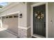 Close up on the front door with decorative wreath, stone accents and view of the garage at 10177 Spring Lake Dr, Clermont, FL 34711