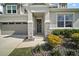 Elegant entryway featuring stone accents, yellow flowering bushes and a decorative wreath on the front door at 10177 Spring Lake Dr, Clermont, FL 34711