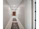 Bright hallway with tile floors, light gray walls and view of a hutch at the end of the hall at 10177 Spring Lake Dr, Clermont, FL 34711