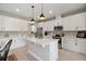 Bright kitchen featuring white cabinetry, a central island, and stainless steel appliances at 10177 Spring Lake Dr, Clermont, FL 34711