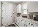 Bright pantry featuring white cabinets, countertops, and a door to the outside at 10177 Spring Lake Dr, Clermont, FL 34711