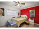 Bedroom featuring a large red accent wall, a ceiling fan, and plenty of natural light at 1100 E Caroline St # 218, Tavares, FL 32778