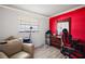 Bedroom featuring a red accent wall and neutral decor at 1100 E Caroline St # 218, Tavares, FL 32778