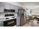 Open kitchen featuring stainless steel appliances, a white range, and grey cabinets at 1100 E Caroline St # 218, Tavares, FL 32778