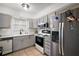 Kitchen featuring stainless steel appliances, a white range, and grey cabinets at 1100 E Caroline St # 218, Tavares, FL 32778