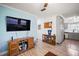 Living room with hardwood floors, flat-screen TV, and a display cabinet filled with sports memorabilia at 1100 E Caroline St # 218, Tavares, FL 32778