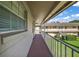 Long walkway with metal railing connecting units in the building, with views of the lawn and landscaping at 1100 E Caroline St # 218, Tavares, FL 32778