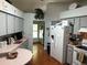 View of the kitchen showcasing the grey cabinetry, white appliances, and wood flooring at 1108 Ben Hope Dr, Leesburg, FL 34788