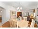 Inviting dining space with wood floors, light wood table, and living room view at 1202 San Bernardo Rd, The Villages, FL 32162