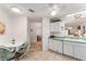 Open-concept kitchen with white cabinets, green countertops, and tile floors connecting to the entryway at 1202 San Bernardo Rd, The Villages, FL 32162