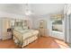 Comfortable main bedroom with wood floor, mirrored vanity and a bright window at 1202 San Bernardo Rd, The Villages, FL 32162