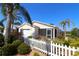 Charming single-story home with tropical landscaping and a white picket fence at 1215 Eagle Ridge Dr, The Villages, FL 32162