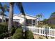 Attractive single-story home with screened porch and tropical landscaping with a white picket fence at 1215 Eagle Ridge Dr, The Villages, FL 32162