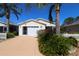 Beautiful single-story home with an attached garage and tropical landscaping at 1215 Eagle Ridge Dr, The Villages, FL 32162