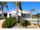 Single-story home with tropical landscaping and a white picket fence at 1215 Eagle Ridge Dr, The Villages, FL 32162