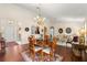 Formal dining room featuring hardwood floors, an elegant chandelier, and a round wooden table with seating for four at 12225 Se 173Rd Pl, Summerfield,, FL 34491