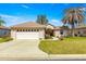 Well-maintained home exterior with a two-car garage and a manicured front lawn at 12225 Se 173Rd Pl, Summerfield,, FL 34491