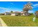 Single-story home with manicured front lawn, mature palm tree, and a two-car garage under a bright blue sky at 12225 Se 173Rd Pl, Summerfield,, FL 34491