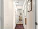 Bright hallway with neutral walls, a decorative rug, and views into the bedroom and bathroom at 12225 Se 173Rd Pl, Summerfield,, FL 34491