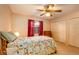 Comfortable bedroom with a ceiling fan, closet, and window dressed with drapes at 12418 Clubhouse Ct, Tavares, FL 32778