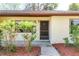 Close-up of the inviting front entry with mature landscaping at 12418 Clubhouse Ct, Tavares, FL 32778