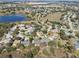 An aerial view showing homes nestled in a lush, established neighborhood with a tranquil lake nearby at 12626 Douglas Fir Ct, Clermont, FL 34711