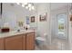 A well-lit bathroom featuring tiled floors, vanity, toilet and direct access to the pool area at 12626 Douglas Fir Ct, Clermont, FL 34711