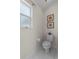 Compact half-bathroom features tile floor and base, as well as decoratice artwork at 12626 Douglas Fir Ct, Clermont, FL 34711