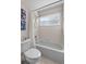 Bright bathroom features a shower and tub combination with a white shower curtain and tiled walls at 12626 Douglas Fir Ct, Clermont, FL 34711