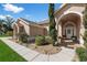 Inviting front entrance with a covered porch, arched doorway, and decorative landscaping for a warm welcome at 12626 Douglas Fir Ct, Clermont, FL 34711