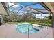 Inviting screened-in pool and spa area perfect for relaxation and entertaining with views of the lush backyard at 12626 Douglas Fir Ct, Clermont, FL 34711