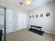 Neutral bedroom with doors, carpet, and workout bench beneath framed art at 12919 Freeman St, Windermere, FL 34786