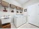 Bright laundry area with washer, dryer, utility sink, and shelving at 12919 Freeman St, Windermere, FL 34786