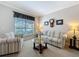 Cozy living room featuring a comfortable striped sofa, armchair, and a decorative coffee table at 12919 Freeman St, Windermere, FL 34786