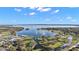 Panoramic aerial view of a lake with a marina, pedestrian bridge, and a vibrant lakeside community at 1322 Howard Rd, Leesburg, FL 34748