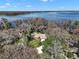 Aerial shot of house near water showing lush landscaping and trees with lake view at 1322 Howard Rd, Leesburg, FL 34748