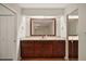 Bathroom with a large mirror, marble countertop, and wood cabinets at 1322 Howard Rd, Leesburg, FL 34748