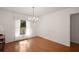 Bright dining room with hardwood floors, chandelier, and natural light from the large window at 1322 Howard Rd, Leesburg, FL 34748