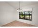 Cozy dining room featuring tile floors, a modern chandelier, and a large window with views of the outdoor scenery at 1322 Howard Rd, Leesburg, FL 34748