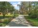 Long driveway leading to a charming home with mature trees and landscaping creating privacy at 1322 Howard Rd, Leesburg, FL 34748