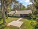 Single-story home surrounded by mature trees and lush landscaping at 1322 Howard Rd, Leesburg, FL 34748